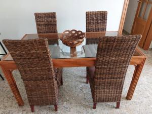 una mesa de comedor con sillas de mimbre y una cesta. en AMPURDAN Bella Vista, en Torre del Mar