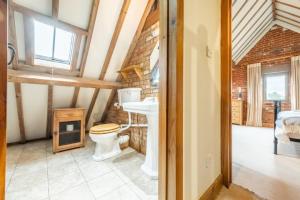 a bathroom with a toilet and a sink at The Cart Shed NC in North Creake