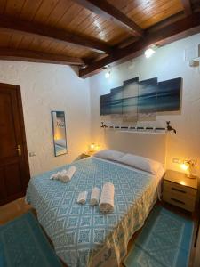 a bedroom with a bed with towels on it at L'Uliveto HOLIDAY HOUSE -Casa Vacanze Indipendente- in Muravera