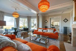 a living room with orange couches and a zebra at The Ballroom in Blakeney
