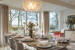 a dining room with a long table and a large window at The Ballroom in Blakeney
