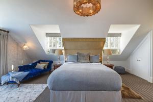 a bedroom with a large bed and a blue couch at The Ballroom in Blakeney