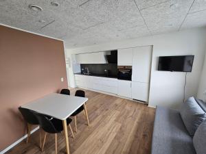 uma sala de estar com uma mesa e um sofá em Brand new apartment with stunning skyline views em Tórshavn