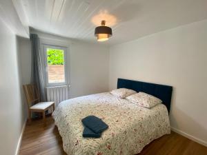 a bedroom with a bed with a blue headboard and a window at Sur la route des Vins Maison proche Saint Emilion in Sainte-Terre