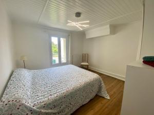 a white bedroom with a bed and a window at Sur la route des Vins Maison proche Saint Emilion in Sainte-Terre