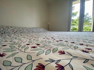 a bedroom with a bed with a floral bedspread at Sur la route des Vins Maison proche Saint Emilion in Sainte-Terre