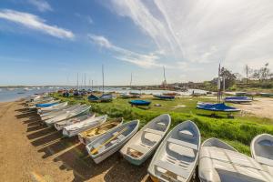 a row of boats are lined up on the beach at Teacup Cottage in Syderstone