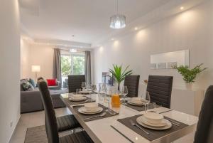 a dining room and living room with a table and chairs at Albufeira Old Town Center - VERASOL 1 in Albufeira