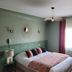 - une chambre avec un grand lit et une tête de lit verte dans l'établissement Hôtel Rive Sud, à Chinon