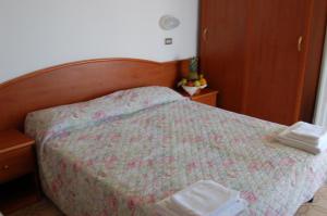 una camera da letto con un letto con un copriletto sopra di Hotel Villa Verde a San Mauro a Mare
