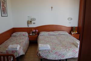 una camera d'albergo con due letti e asciugamani di Hotel Villa Verde a San Mauro a Mare
