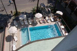 een uitzicht over een zwembad met stoelen en parasols bij Hotel Villa Verde in San Mauro a Mare