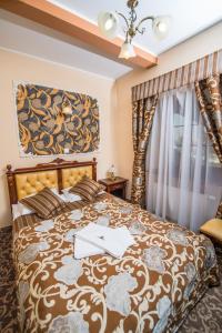 a bedroom with a bed with a brown bedspread at Hotel & Restauracja Gniecki in Hrubieszów