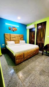 una camera con un grande letto su una parete blu di Ms Residency a Nuova Delhi