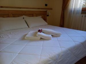 ein weißes Bett mit Handtüchern darüber in der Unterkunft RESIDENZA BERETTA Como Lake -A- in Orsenigo