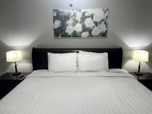 a bedroom with a white bed with two lamps at Luxury Modern Condo by the Lake - Breezy Escape in Branson