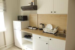 cocina con fregadero y nevera blanca en Modern Apartment in Jekabpils, en Jēkabpils