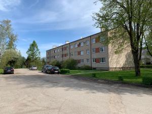 Modern Apartment in Jekabpils في جيكاببيلس: مبنى فيه سيارات تقف على جانب شارع
