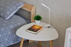 a table with a book on it next to a bed at Modern Apartment in Jekabpils in Jēkabpils