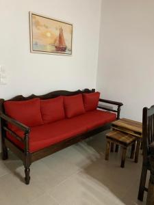 a red couch sitting in a room with two chairs at Villa Vigla in Zefiría