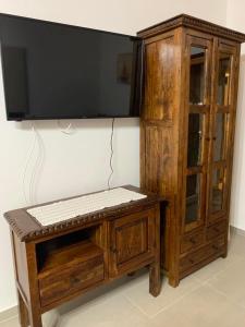 a wooden cabinet with a flat screen tv on top at Villa Vigla in Zefiría