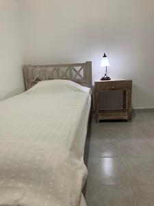 a bedroom with a bed and a table with a lamp at Villa Vigla in Zefiría