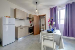 una cocina con nevera blanca y una mesa con flores. en Cosy 1BR Studio Central Location, en Sliema