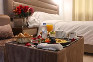 un vassoio di prodotti per la colazione su un tavolo in una camera d'albergo di Hôtel Des Lilas a Oujda