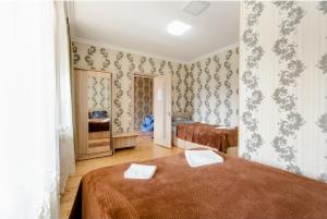 a bedroom with two beds in a room with wallpaper at Hotel Garbani in Stepantsminda
