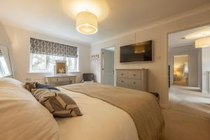 a bedroom with a large bed and a television at Harp Garden in Fakenham
