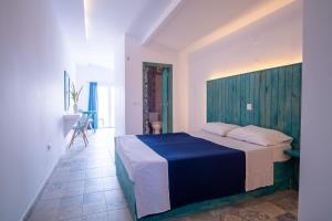 a bedroom with a large bed with a blue blanket at Ta Kymata Karpathos in Karpathos Town