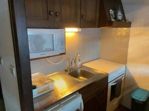 a small kitchen with a sink and a microwave at Duplex sur Morzine avec vue imprenable in Morzine