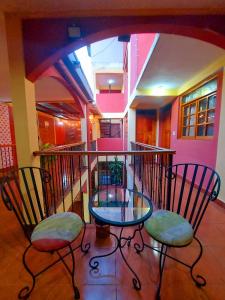 a balcony with a glass table and two chairs at Hostal Lolita's Boutique in Granada