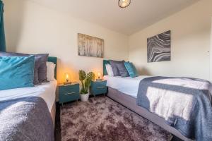 two beds in a room with blue and white at Homestead in Northrepps