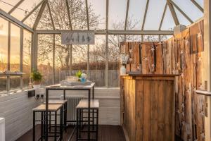 a greenhouse with stools and a bar in it at Homestead in Northrepps