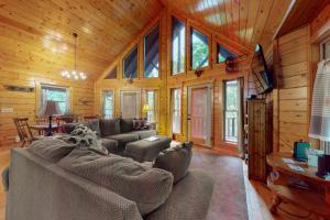een woonkamer met een bank en een tv in een huisje bij Lazy Bear Lodge in Ranger