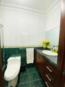y baño con aseo y lavamanos. en Big House, en Guayaquil