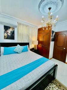 um quarto com uma cama e um lustre em Big House em Guayaquil