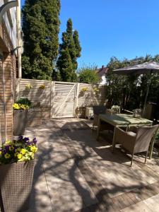 une terrasse avec une table, des chaises et un parasol dans l'établissement Sopocki apartament i taras, à Sopot