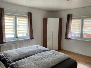 Oberferlach的住宿－Landhaus Graf，一间卧室设有两张床和两个窗户。