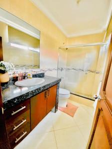 y baño con lavabo, ducha y aseo. en Big House en Guayaquil