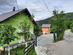 un edificio verde con una valla junto a una carretera en Apartmani Vila na Drini, en Foča