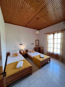 Un dormitorio con dos camas y techo de madera. en Gian Petro Apartments, en Sidari