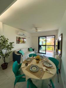 ein Wohnzimmer mit einem Tisch und einem Sofa in der Unterkunft Apartamento no Porto Real Resort com vista para praia para 6 adultos e 4 adolescentes in Mangaratiba