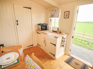 a small kitchen with a counter and a table in a room at Le Petite Pound House in Kidderminster