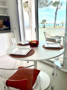 una mesa y sillas blancas con vistas a la playa en Windsurf Beach Front en Torre Grande
