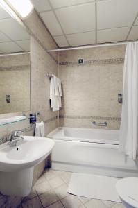 a bathroom with a tub and a sink and a toilet at Hotel Dukla in Prešov