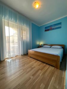 a bedroom with a bed and a large window at Apartments Armin in Ližnjan