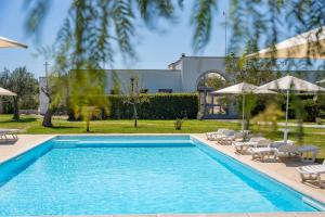 uma piscina com espreguiçadeiras e guarda-sóis em Corte dei Melograni Hotel Resort em Otranto