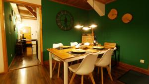 a dining room with a table and a green wall at Green Loft Schwarzwald - Dach-Balkon--Musik-Ecke in Winzeln
